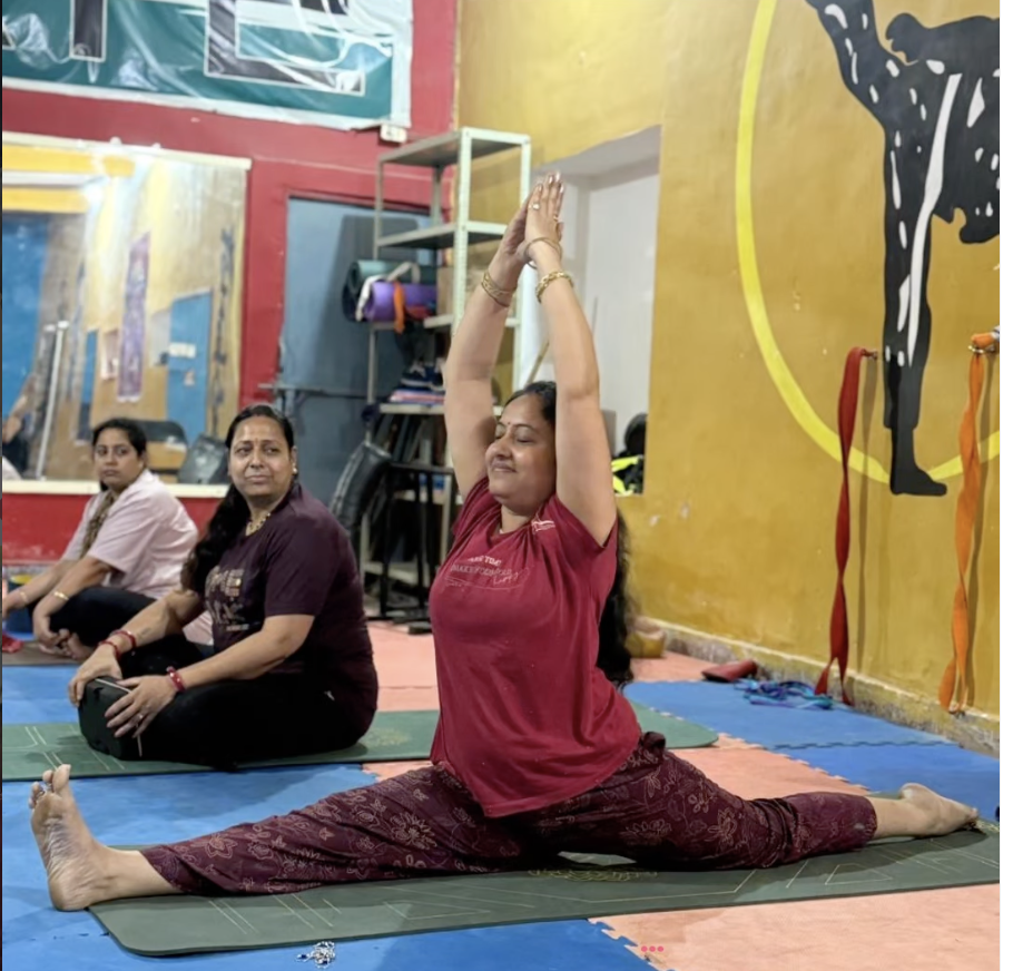 Students in a group yoga class with raised arms