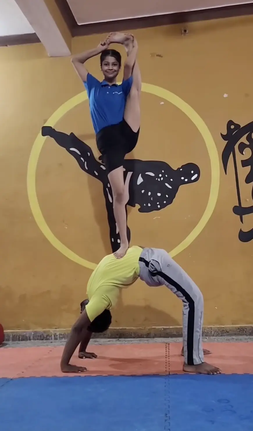 Two young students performing acro yoga